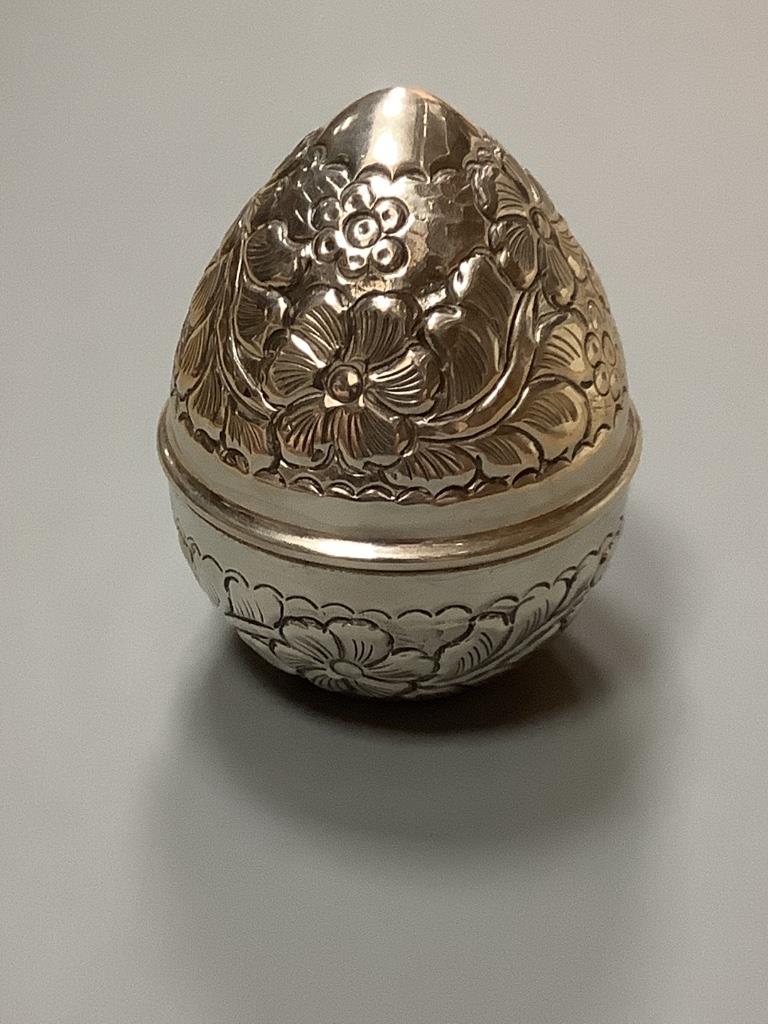 A 20th century Egyptian white metal embossed box and cover, modelled as an egg, post 1946 mark, height 10.7cm, 139 grams.